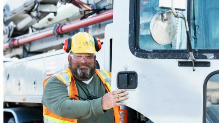 Truck driver with quality industrial hose on his vacuum boom truck