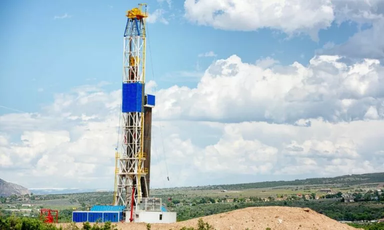 industrial hose incorporated into fracking rig against a cloudy sky