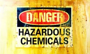 stained yellow chemical hazard sign needed for industrial metal hose transfer